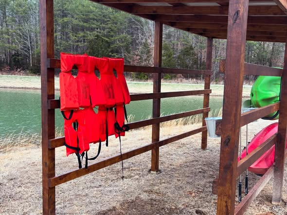 Cedar lakeside storage rack holding kayaks and life vests at the water's edge on Lake Cumberland, KY